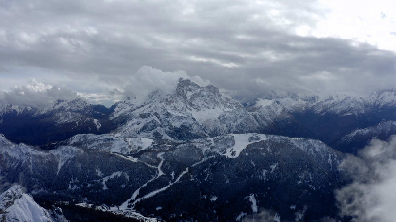 在雪山上的森林的空中美景，无人机在戏剧性的云层上向前飞行-焦山，意大利视频素材