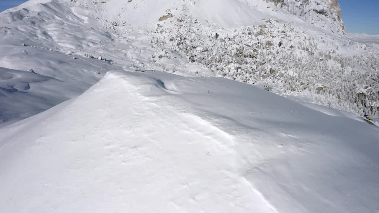 空中向前拍摄岩石对天空，无人机飞行在闪闪发光的雪-塞拉Pass，意大利视频下载