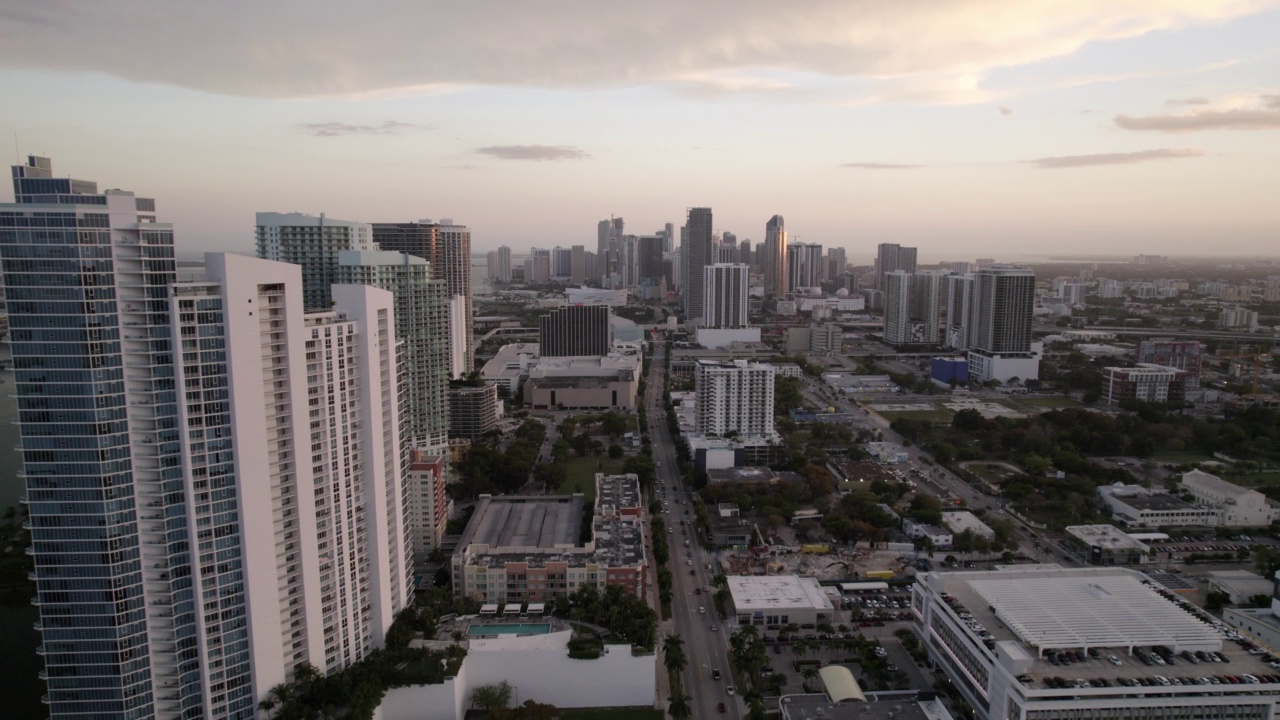 空中前进镜头的汽车移动在道路上的建筑物在云的天空-迈阿密，佛罗里达视频素材