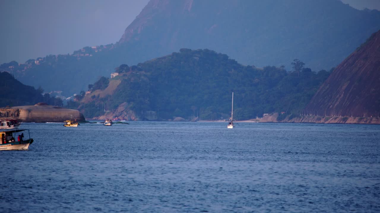 封锁拍摄的人在海上的船只移动在起伏的海上的山脉-里约热内卢，巴西视频素材