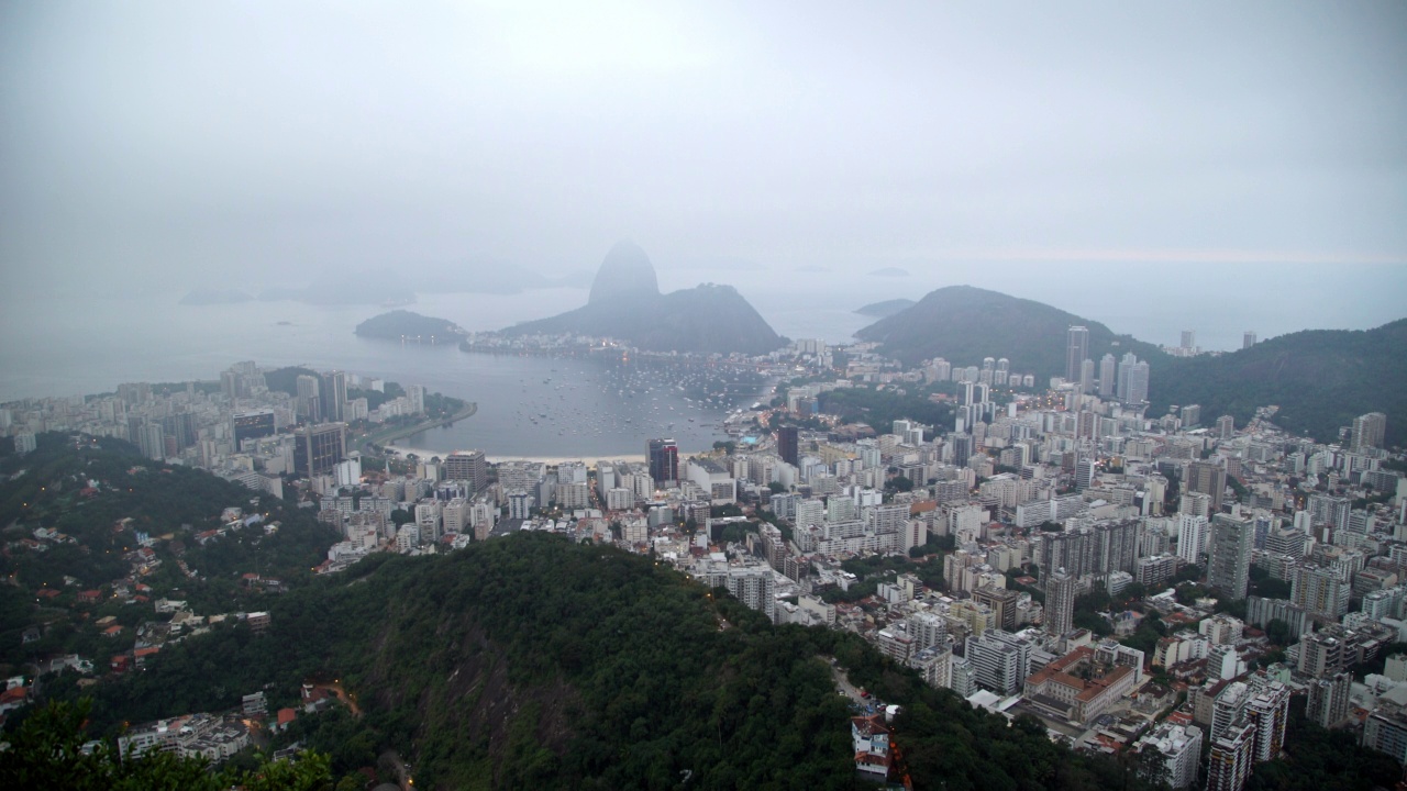 空中封锁拍摄的海上甜面包山的住宅城市在雾天-里约热内卢，巴西视频素材