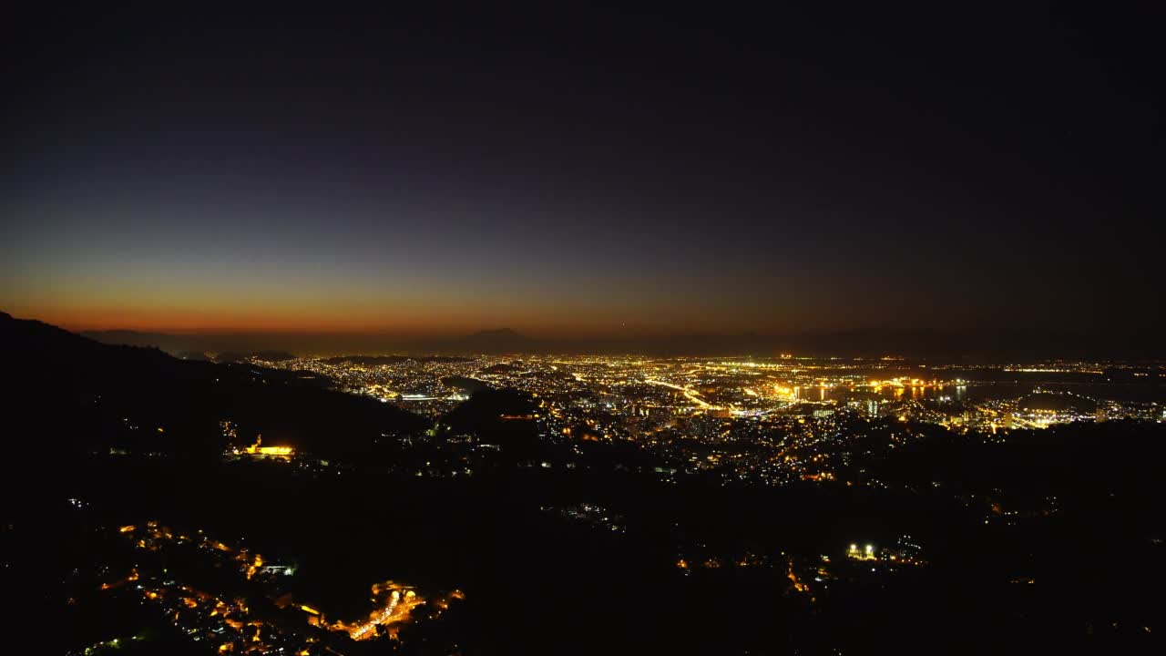 空中延时锁定拍摄闪闪发光的住宅城市在夜间海上-里约热内卢de Janeiro，巴西视频素材