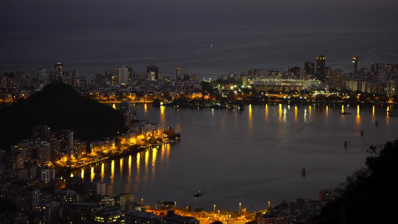 空中封锁延时拍摄的照明城市在夜间海洋-里约热内卢de Janeiro，巴西视频素材