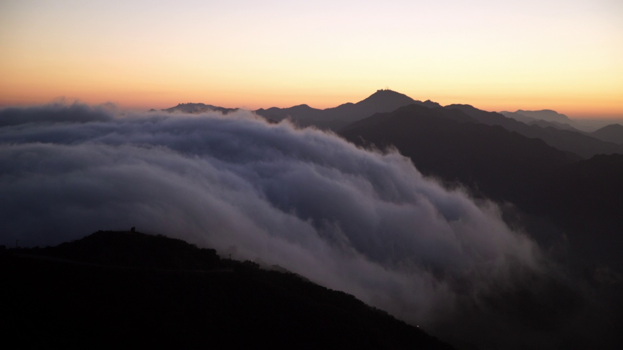 空中封锁拍摄的云在日落期间在山中移动-旧金山，加州视频素材