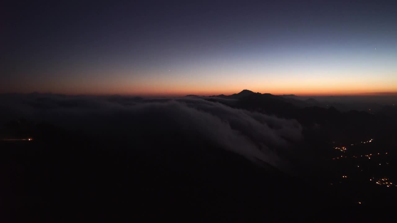 空中慢动作拍摄的云移动在宁静的山由照明城市在日落期间-旧金山，加利福尼亚视频素材