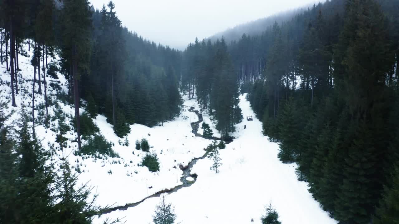 空中慢动作越野车辆移动在雪地森林冷杉在冬天-图林根，德国视频素材