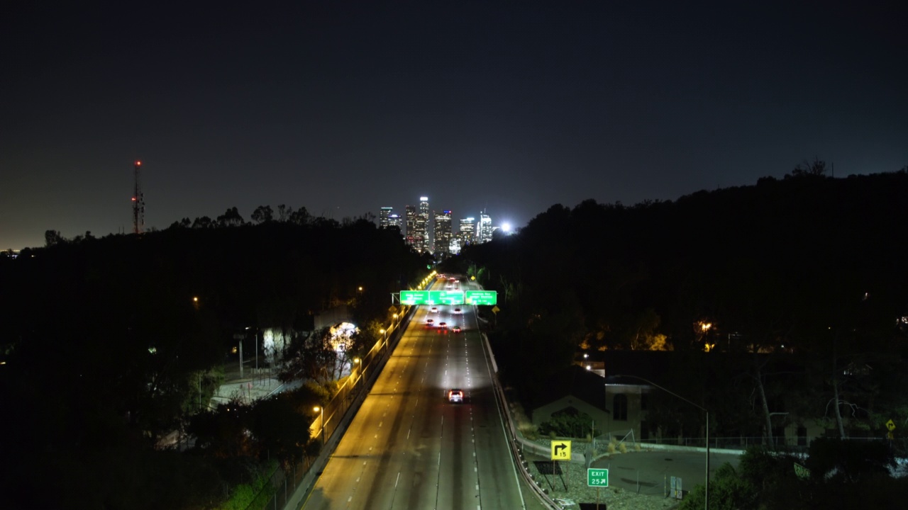 空中封锁拍摄的车辆移动在照明道路在夜晚的城市-洛杉矶，加州视频素材