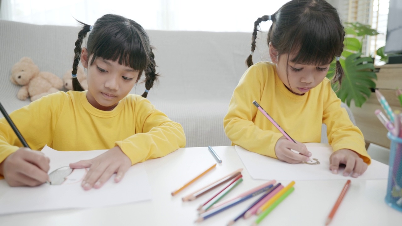 亚洲女孩在家画画的场景。孩子们像童年一样在一起玩耍，节日概念视频素材