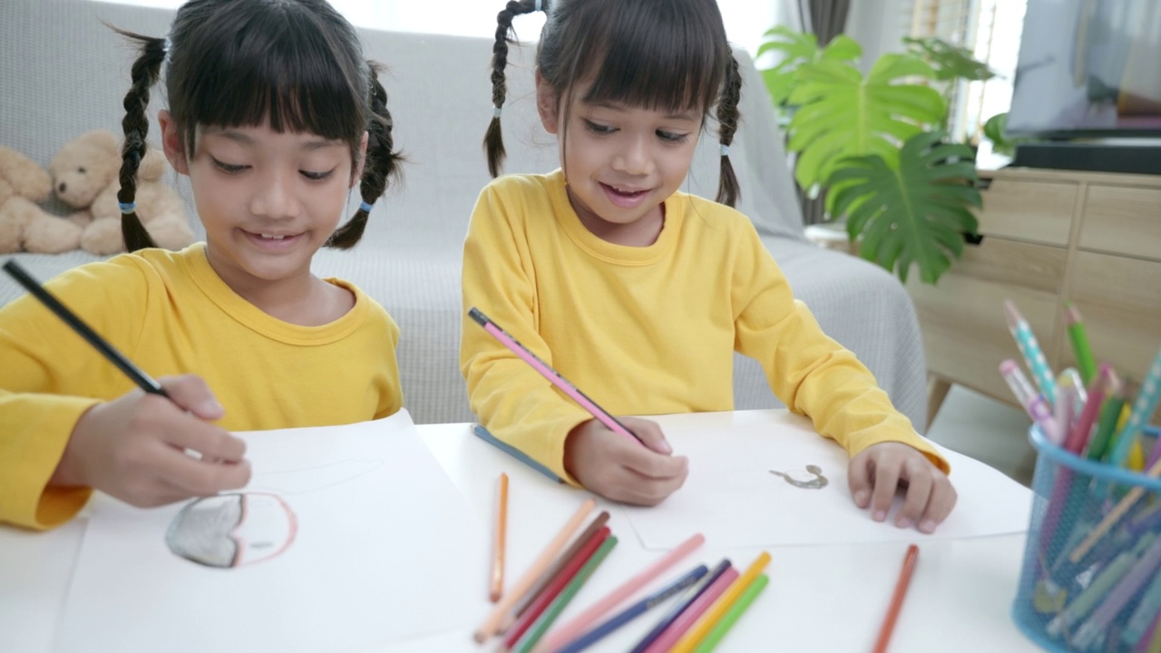 亚洲女孩在家画画的场景。孩子们像童年一样在一起玩耍，节日概念视频素材