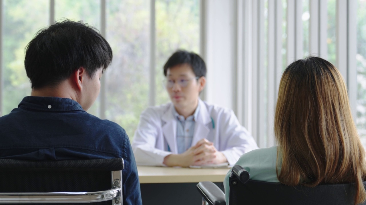 微笑的亚洲男儿科医生为患者提供建议，年轻的亚洲男医生咨询女性患者和在医院检查，保健和援助的概念视频素材