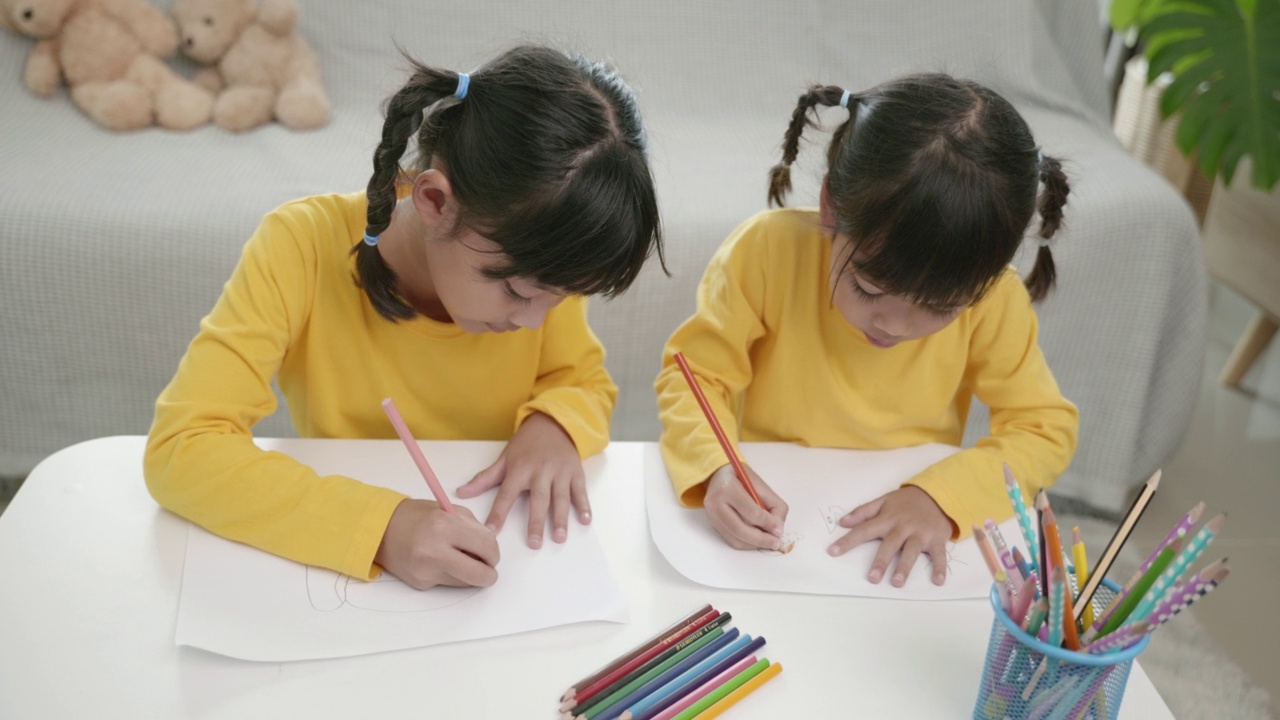 亚洲女孩在家画画的场景。孩子们像童年一样在一起玩耍，节日概念视频素材