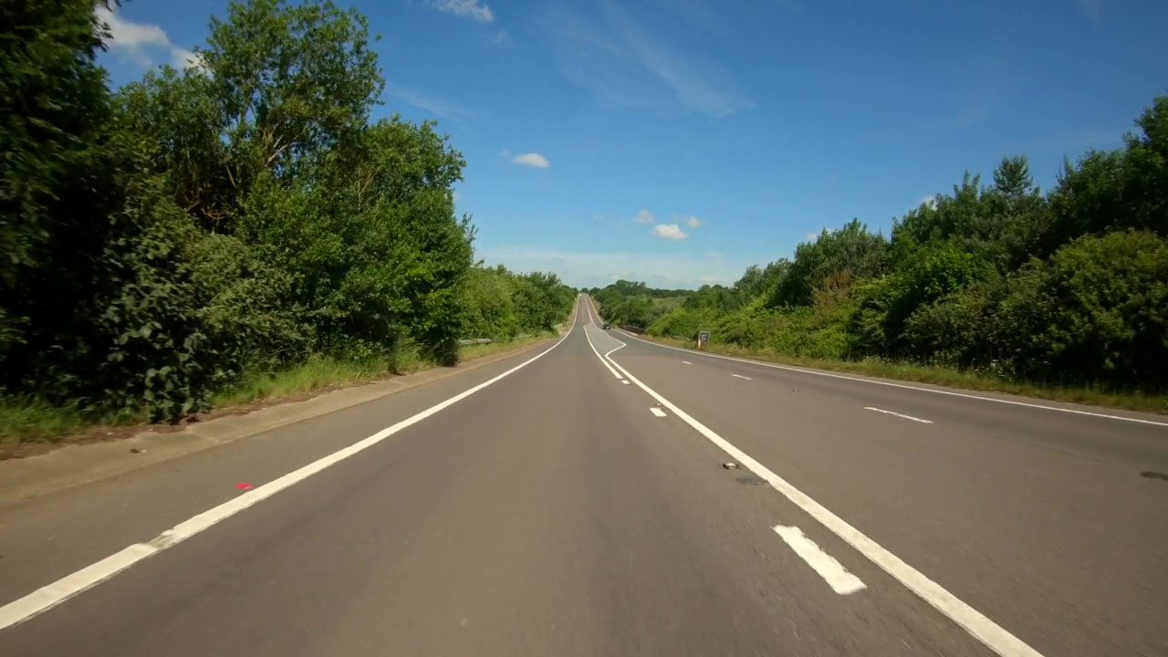 沿着一条笔直的公路行驶，穿过一个山谷。视频素材