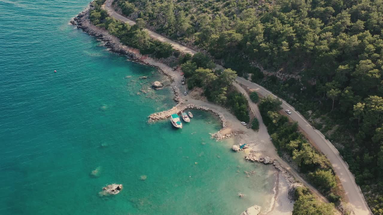 鸟瞰图汽车行驶在蜿蜒的道路上的森林和绿松石海在土耳其视频素材