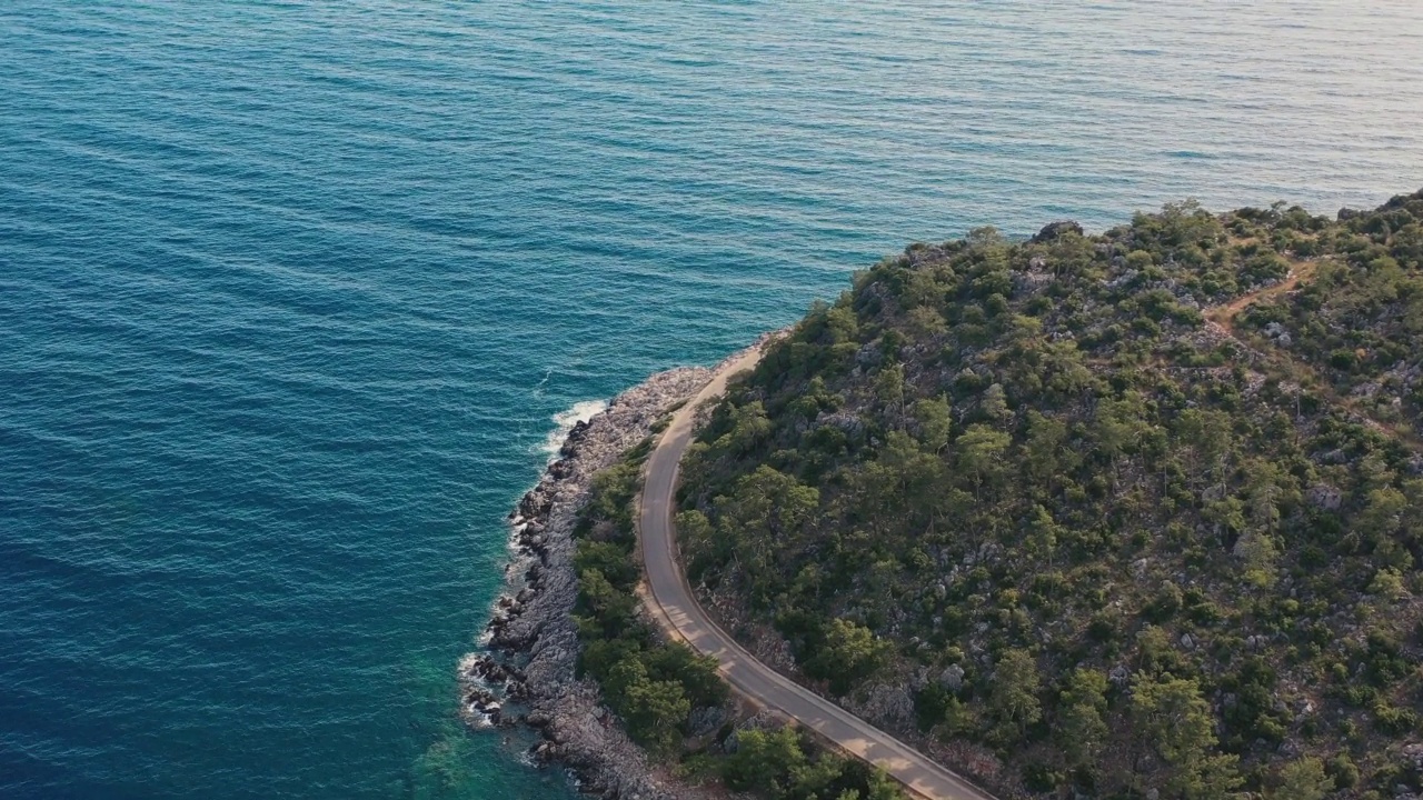 鸟瞰图汽车行驶在蜿蜒的道路上的森林和绿松石海在土耳其视频素材