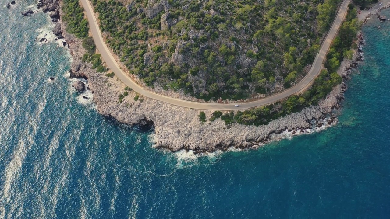 鸟瞰图汽车行驶在蜿蜒的道路上的森林和绿松石海在土耳其视频素材