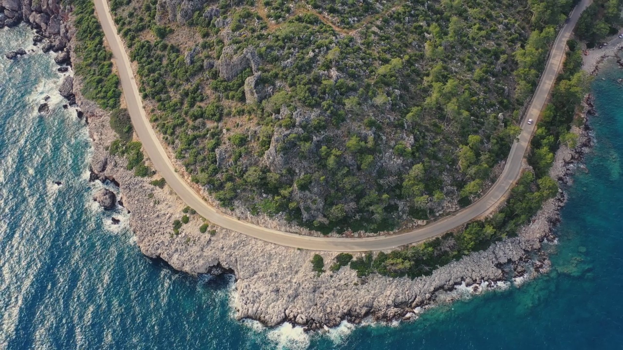 鸟瞰图汽车行驶在蜿蜒的道路上的森林和绿松石海在土耳其视频素材