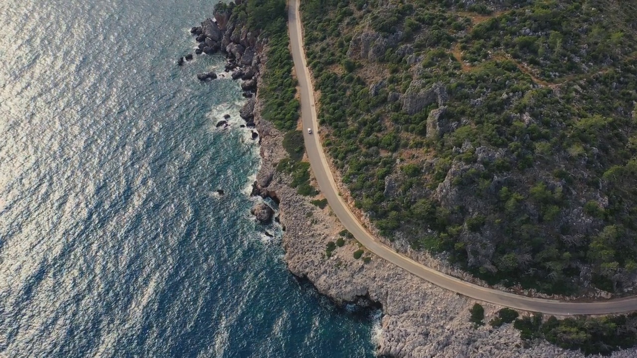 鸟瞰图汽车行驶在蜿蜒的道路上的森林和绿松石海在土耳其视频素材