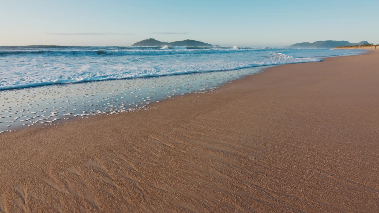 在巴西海滩。太阳升起时，沙滩上浪花翻滚。位于大西洋巴西圣卡塔琳娜岛上的坎佩切镇视频素材