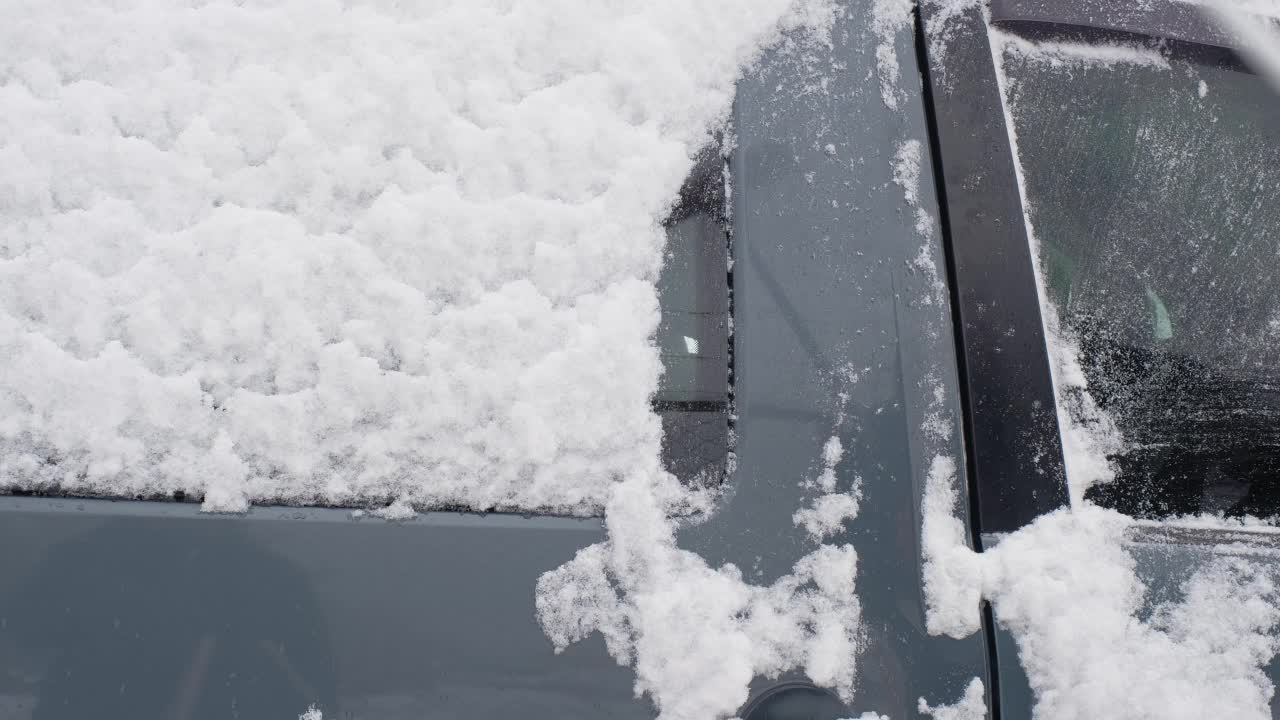 冬天，一名男子用刷子清扫车上的积雪。冬季视频下载