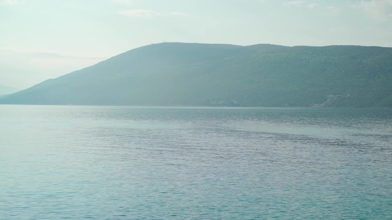 在一个美好的夏日阳光明媚的日子里，可以看到美丽的海湾和山脉视频素材