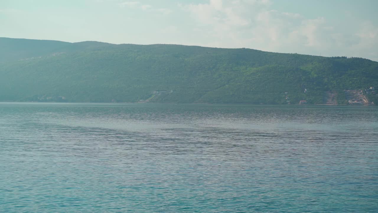 在一个美好的夏日阳光明媚的日子里，可以看到美丽的海湾和山脉视频素材