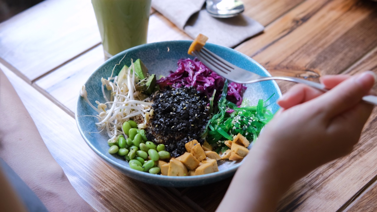 年轻女性吃素食戳碗的特写视频素材