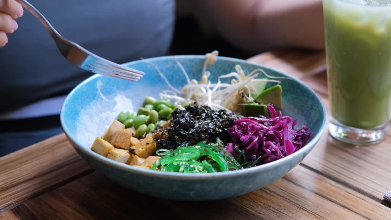 妇女吃健康的素食戳碗午餐视频素材