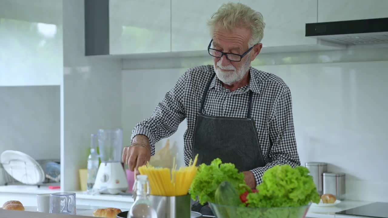 爷爷在厨房里为孙子们准备食物。视频素材