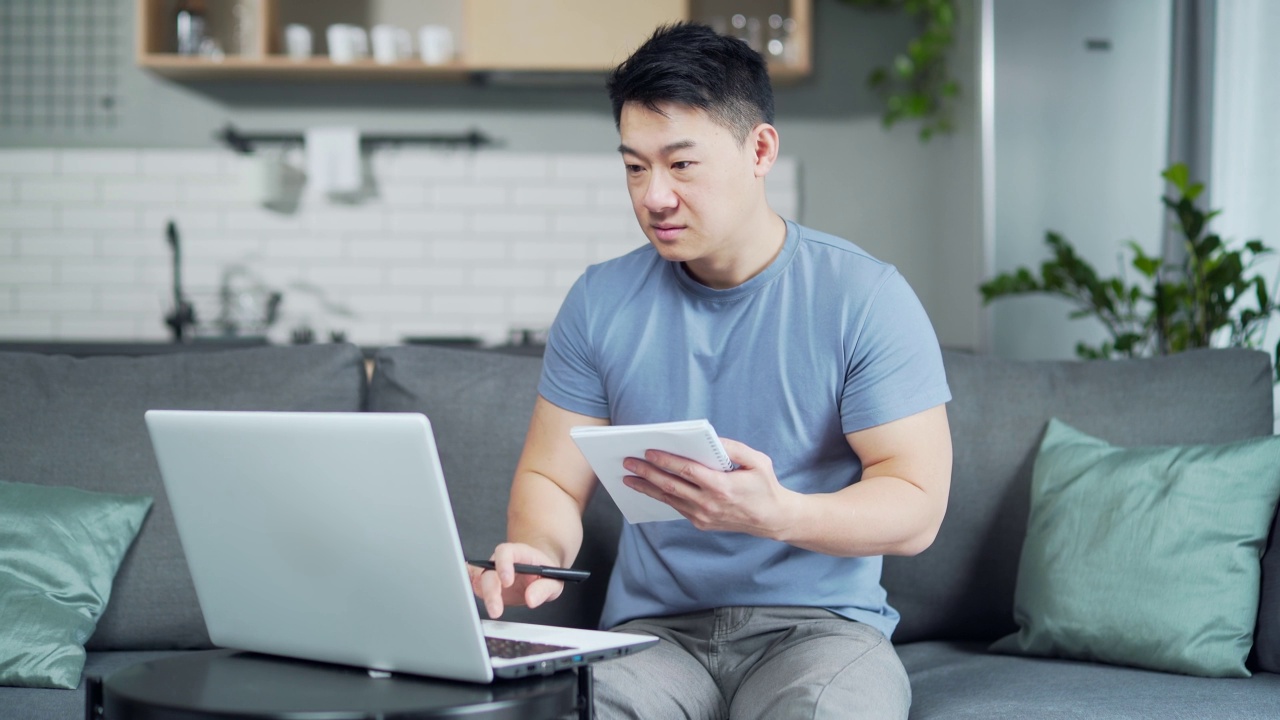 亚洲年轻男性通过在线课程在家上大学。远程教育。男子使用笔记本电脑进行电子学习远程学习在视频电话咨询中寻求建议视频素材