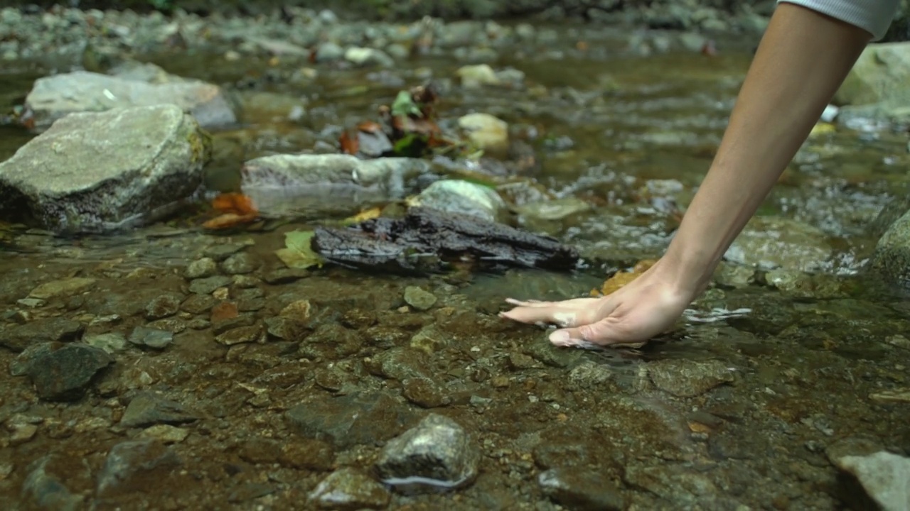 妇女手触摸水在森林、河流或湖泊视频素材