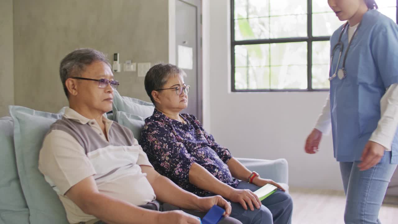 在家庭健康访问期间，与老年病人一起填写表格的保健工作者视频素材