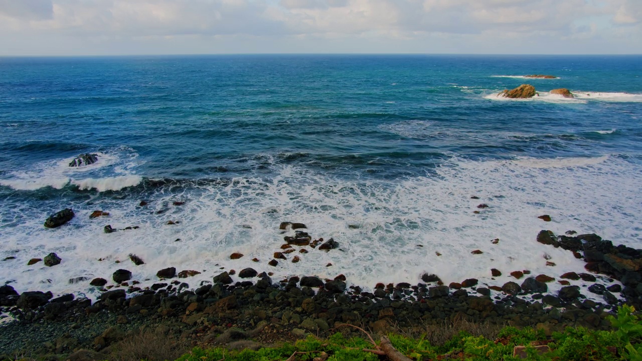 五彩缤纷的海滩，浪花在多石的海岸线上翻腾飞溅。阿纳加自然公园，特内里费北部开阔海域的海浪。视频素材