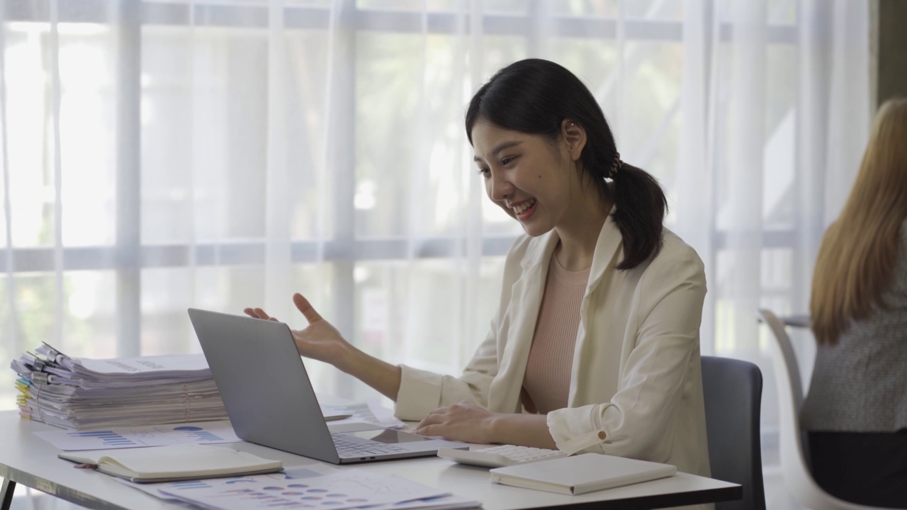 亚洲女性会计，处理财务图表文件，为图表和家庭收入图表报告计算税收。在笔记本电脑上工作并计划费用预算的女商人。视频素材