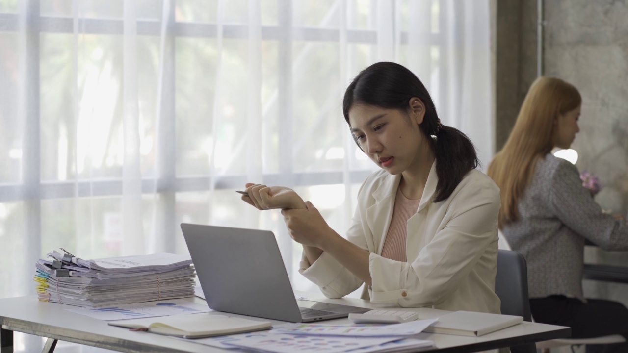 亚洲女性会计，处理财务图表文件，为图表和家庭收入图表报告计算税收。在笔记本电脑上工作并计划费用预算的女商人。视频素材