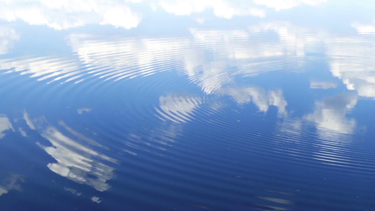 圆圈沿着水面流动，在水中用云反射天空视频素材