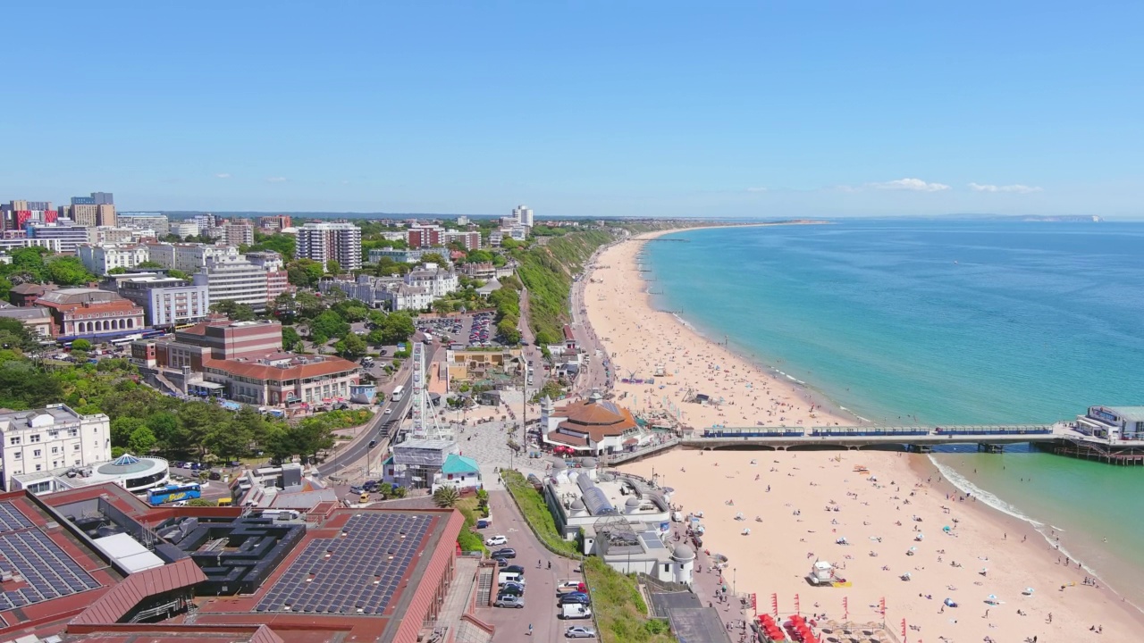 英国伯恩茅斯:英国城市的鸟瞰图，夏天海边度假胜地宽阔的海滩和大西洋的蓝色海水，阳光明媚，天空湛蓝——从上面俯瞰英国的全景视频素材