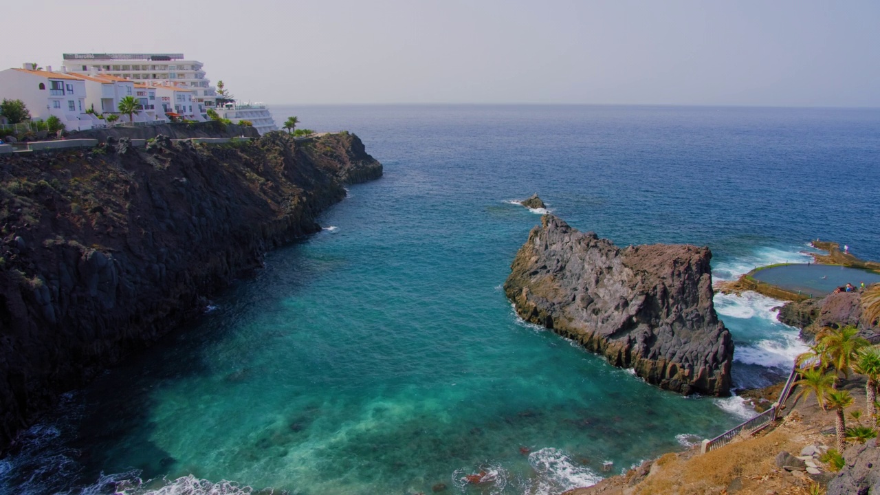 在特内里费岛的圣地亚哥港，碧蓝海浪的海洋岩石火山海岸。巨人Acantilado de Los giants。西班牙加纳利群岛。加维兰海滩和悬崖。视频素材