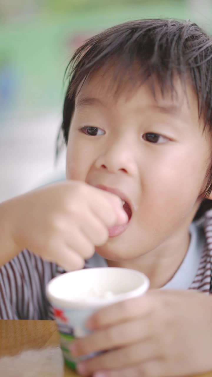 亚洲男孩在自助餐厅吃冰淇淋视频素材