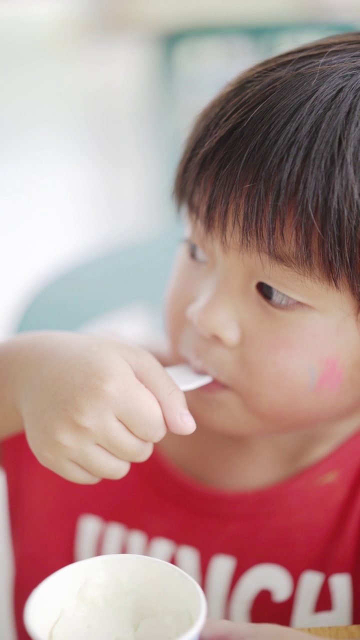 亚洲男孩在自助餐厅吃冰淇淋视频素材