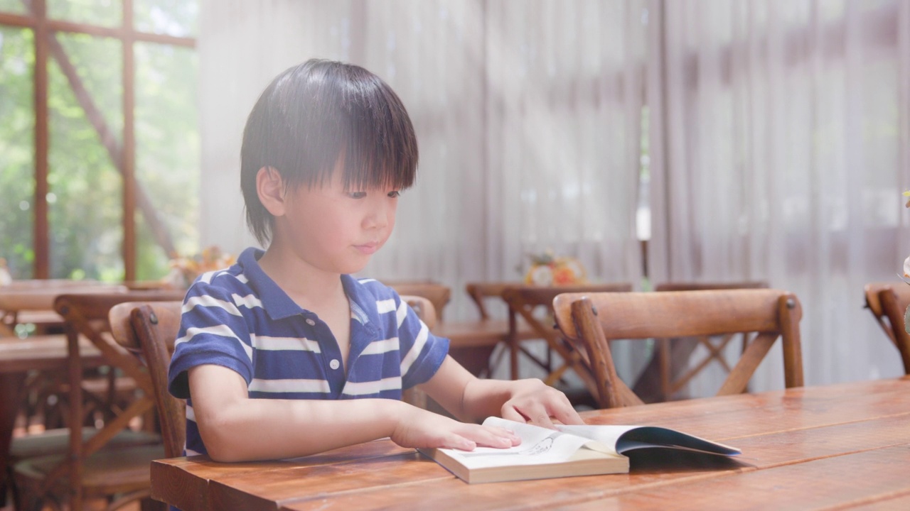 亚洲小男孩在图书馆看书视频素材