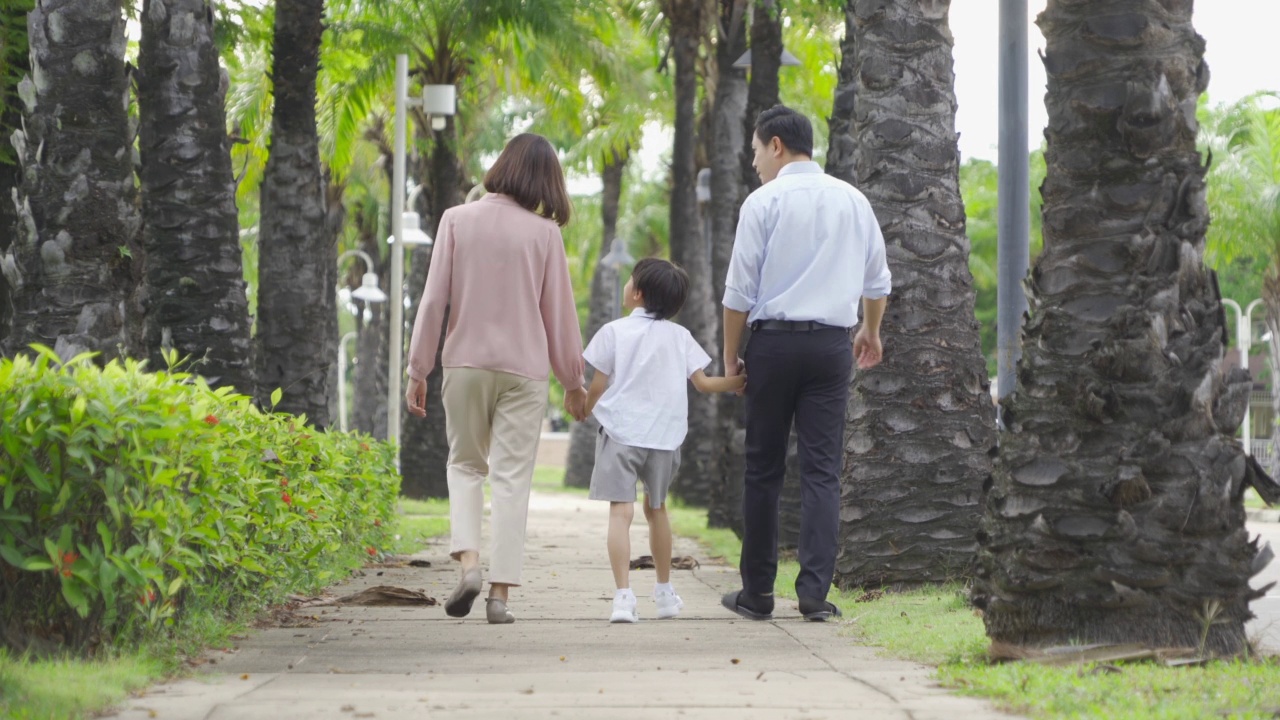 幸福微笑的亚洲家庭肖像一起散步在公共花园公园在家庭关系度假。父亲、母亲和儿子的爱。人们的生活方式。视频素材