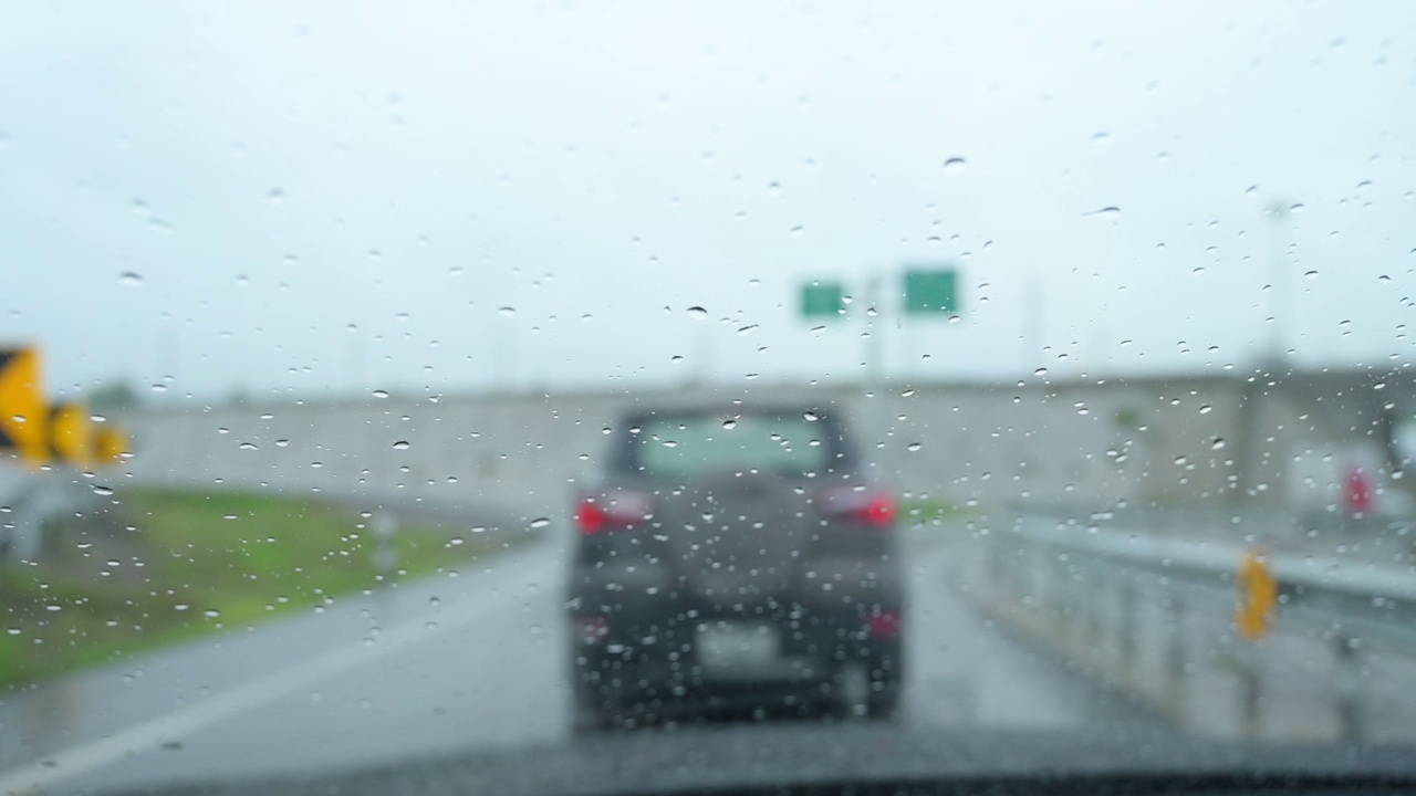 慢动作场景，下雨天开车，雨刷清理雨点落在挡风玻璃上视频素材