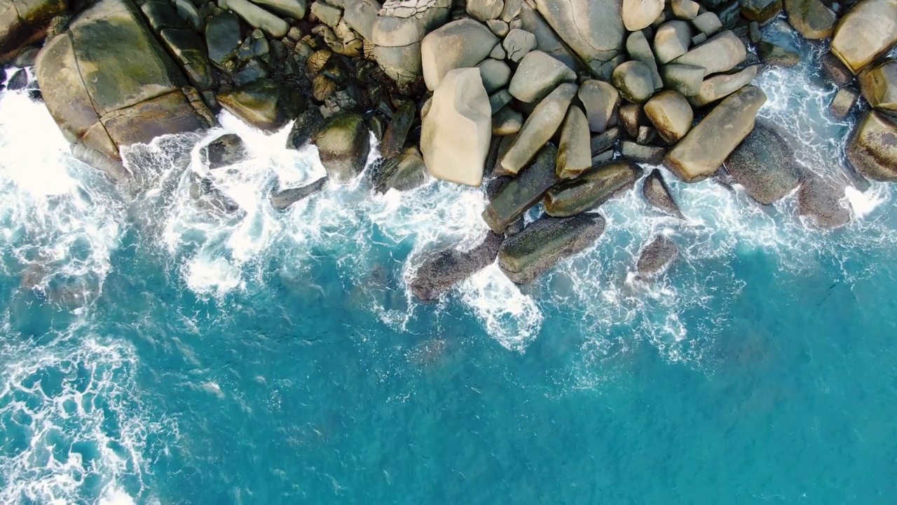 海浪海浪岩石绿松石滚动缓慢撞击岩石海岸线日落天堂岛。4k拷贝空间2022。没有人视频素材