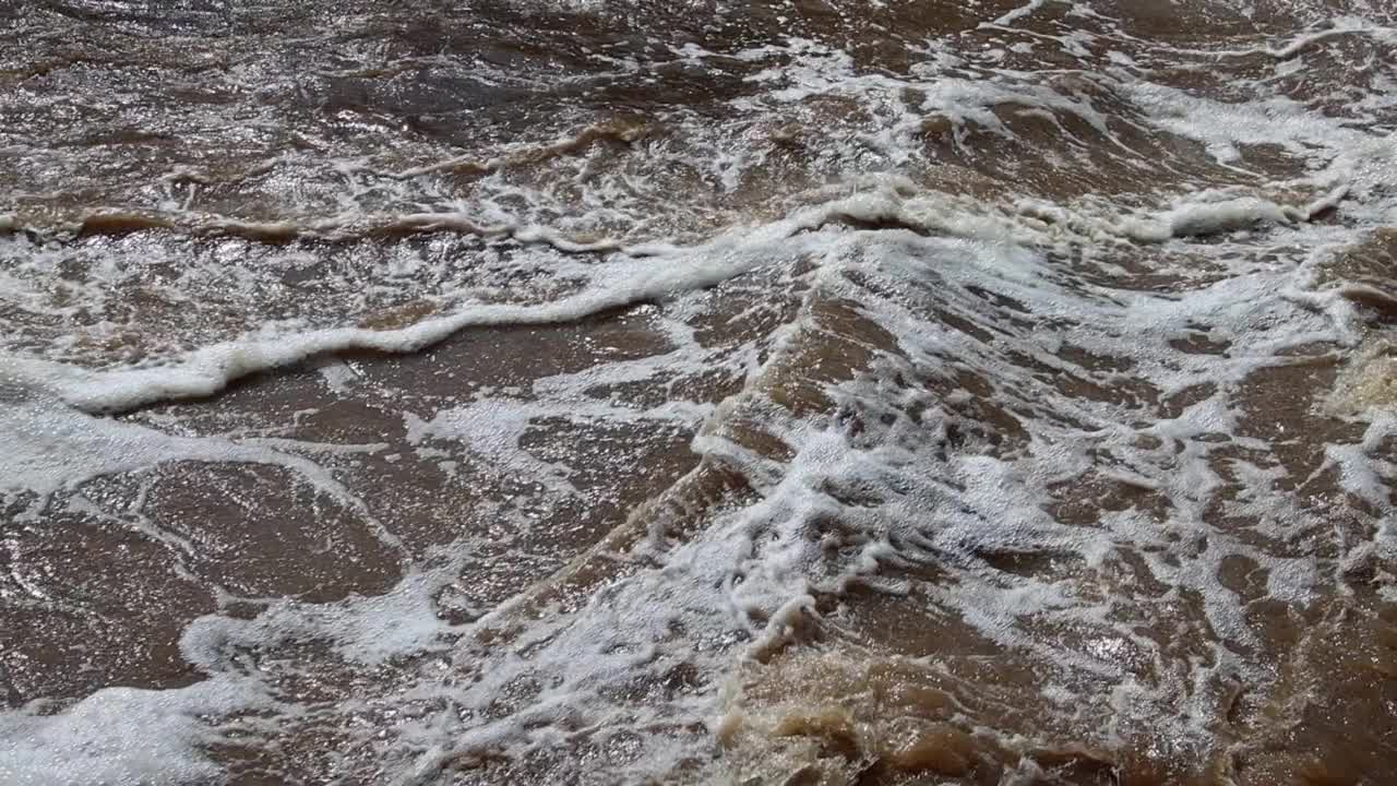 航拍的波浪在洪水的河流，棕色的水背景，慢动作视频素材