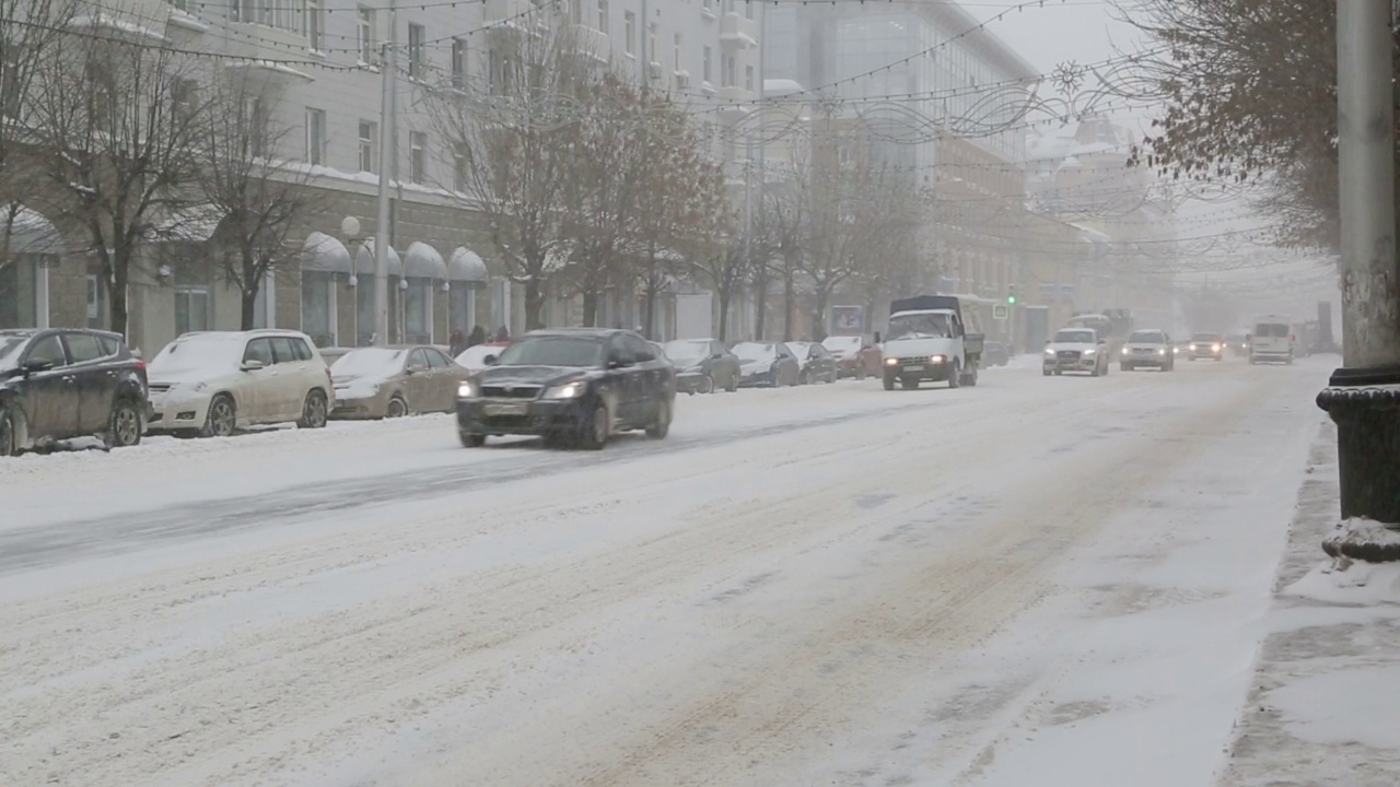 暴风雪中城市街道上的汽车视频素材