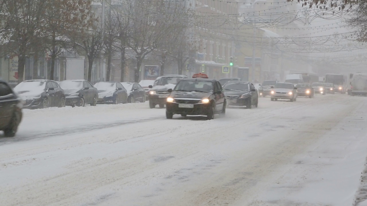 暴风雪中城市街道上的汽车视频素材