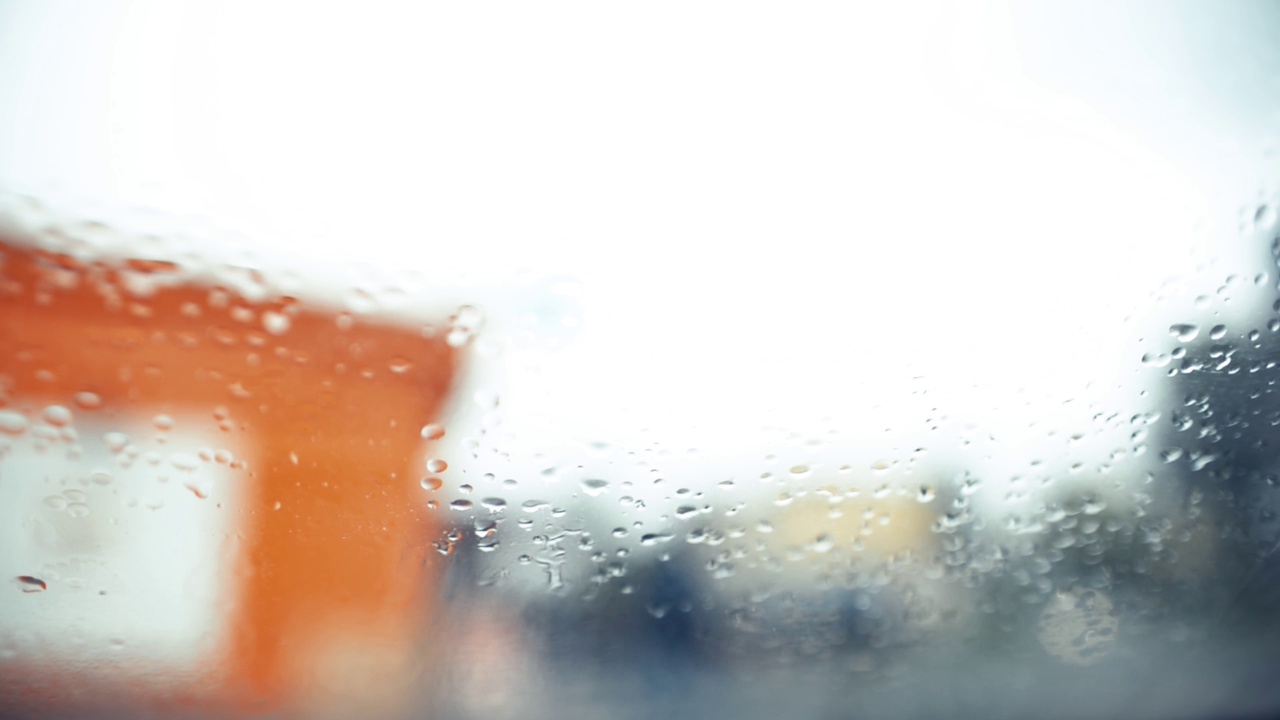 雨滴落在玻璃上，选择性聚焦。背景模糊。概念下雨的天气，悲伤的心情视频素材