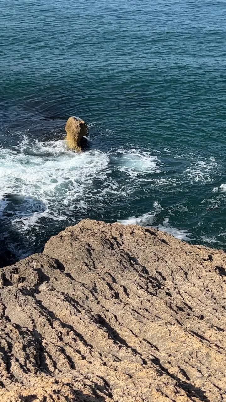 蓝色的惊涛骇浪和海岸岩石。视频素材