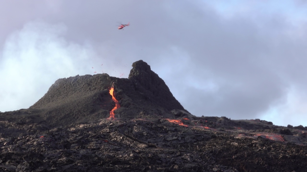 直升机飞过喷发的火山锥视频素材