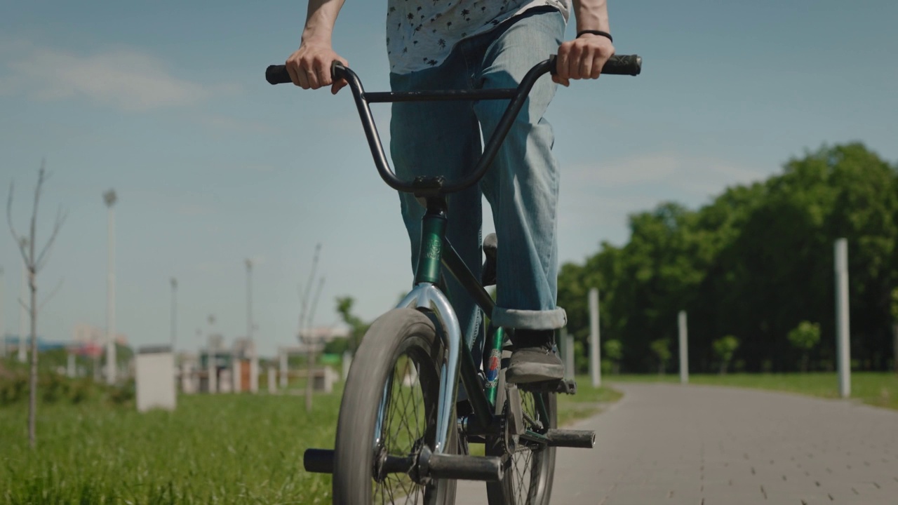 城市里的小轮车极限自行车手。一名男子在城市公园里骑自行车，表演跳跃和特技。视频素材